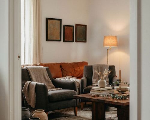 Moody living room with white walls dark furniture and warm layered textures