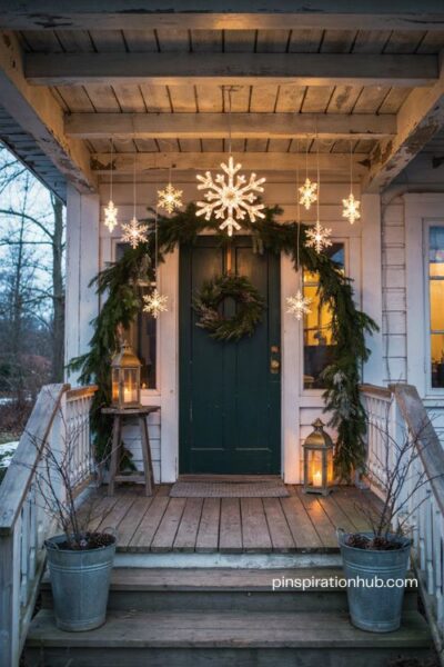 Snowflake lights on the porch with glowing winter decorations above the front door